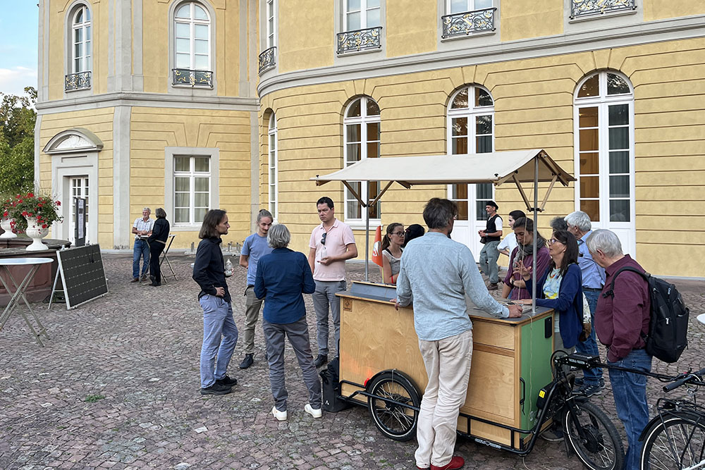 Personen stehen um ein Lastenfahrrad im Innenhof des Karlsruher Schlosses. 